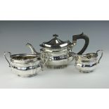 An Edwardian silver three piece tea service, of shaped oval form, with ebony finial and handle,