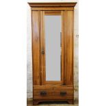 An Edwardian ash wardrobe, with mirror door and drawer,