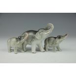 Three Sitzendorf elephant ornaments, each modelled standing and with trunk raised,