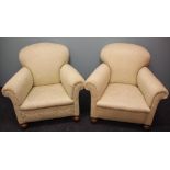 A pair of Edwardian arm chairs, with cream floral upholstery, on turned bun feet,
