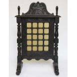 A Victorian carved and stained oak fire screen, with twenty glass panels,