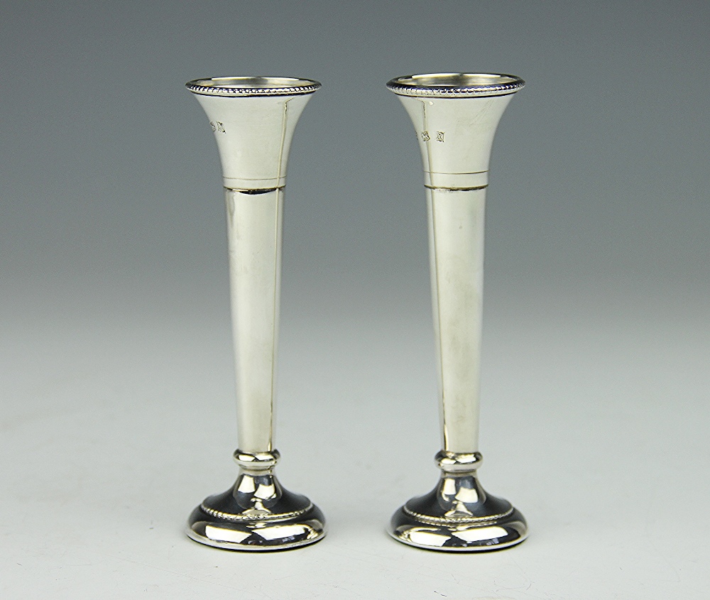 A pair of silver posy vases, Birmingham 1972, each of slender tapering form and with beaded rims,