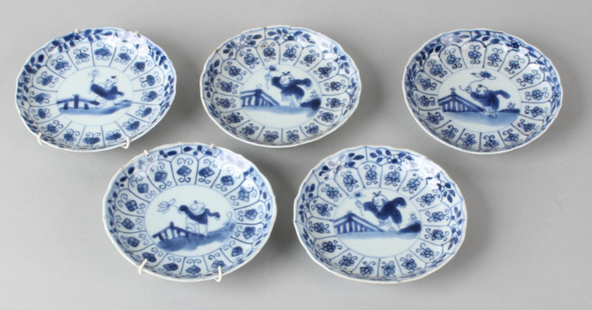 Five 18th century Chinese porcelain dishes with playing children, scalloped edging, four good, one