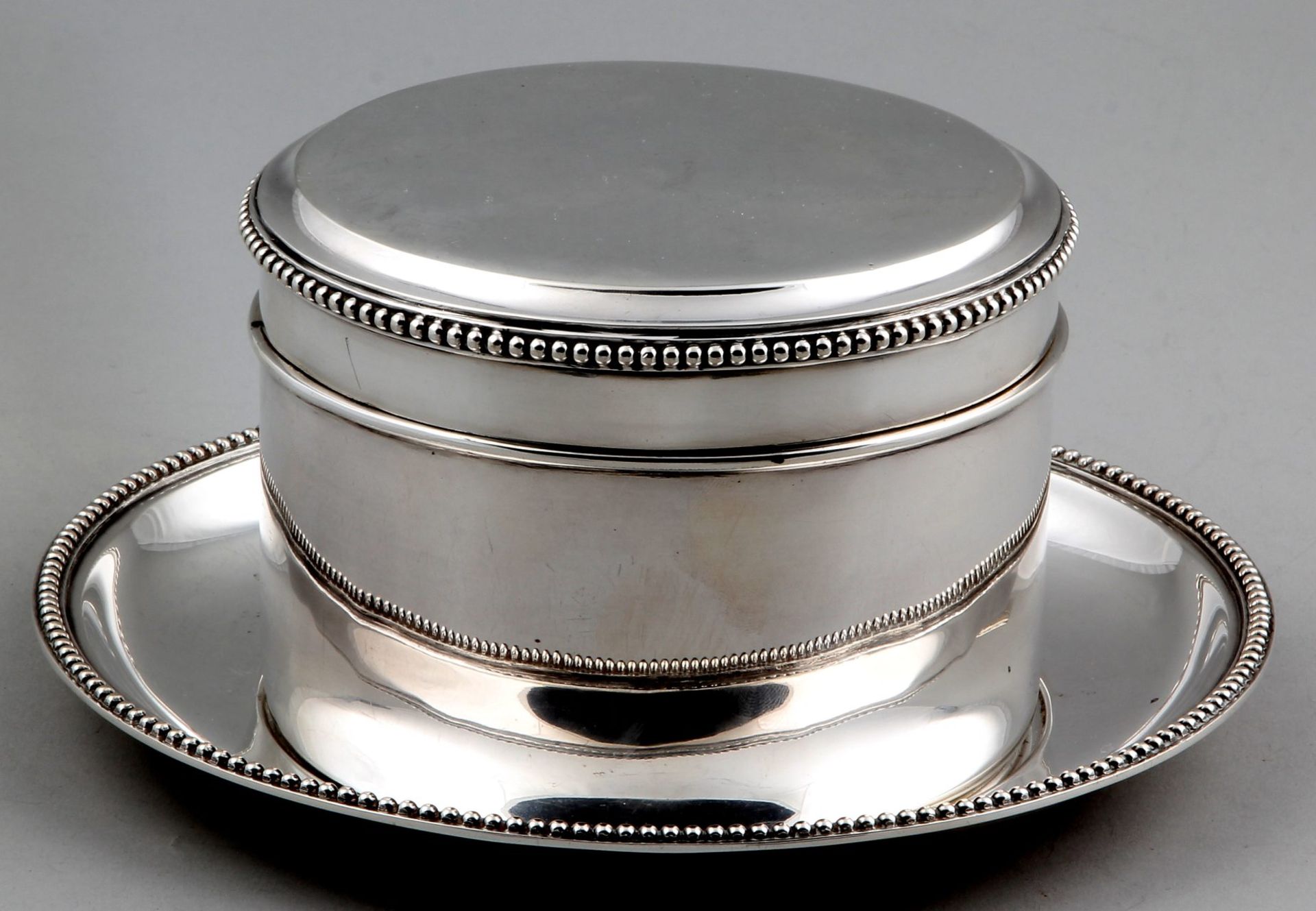 Silver biscuit tin on silver platter, 835/000. Round cookie jar decorated with pearl rim mounted