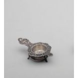 Silver Tea Strainer 800 stamped silver setting footed tea strainer with embossed floral motif. 12 cm