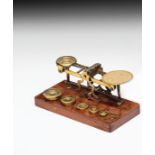 British Postal Scales British, 19th century, wood pedestal, scales and weights made of brass. Set of