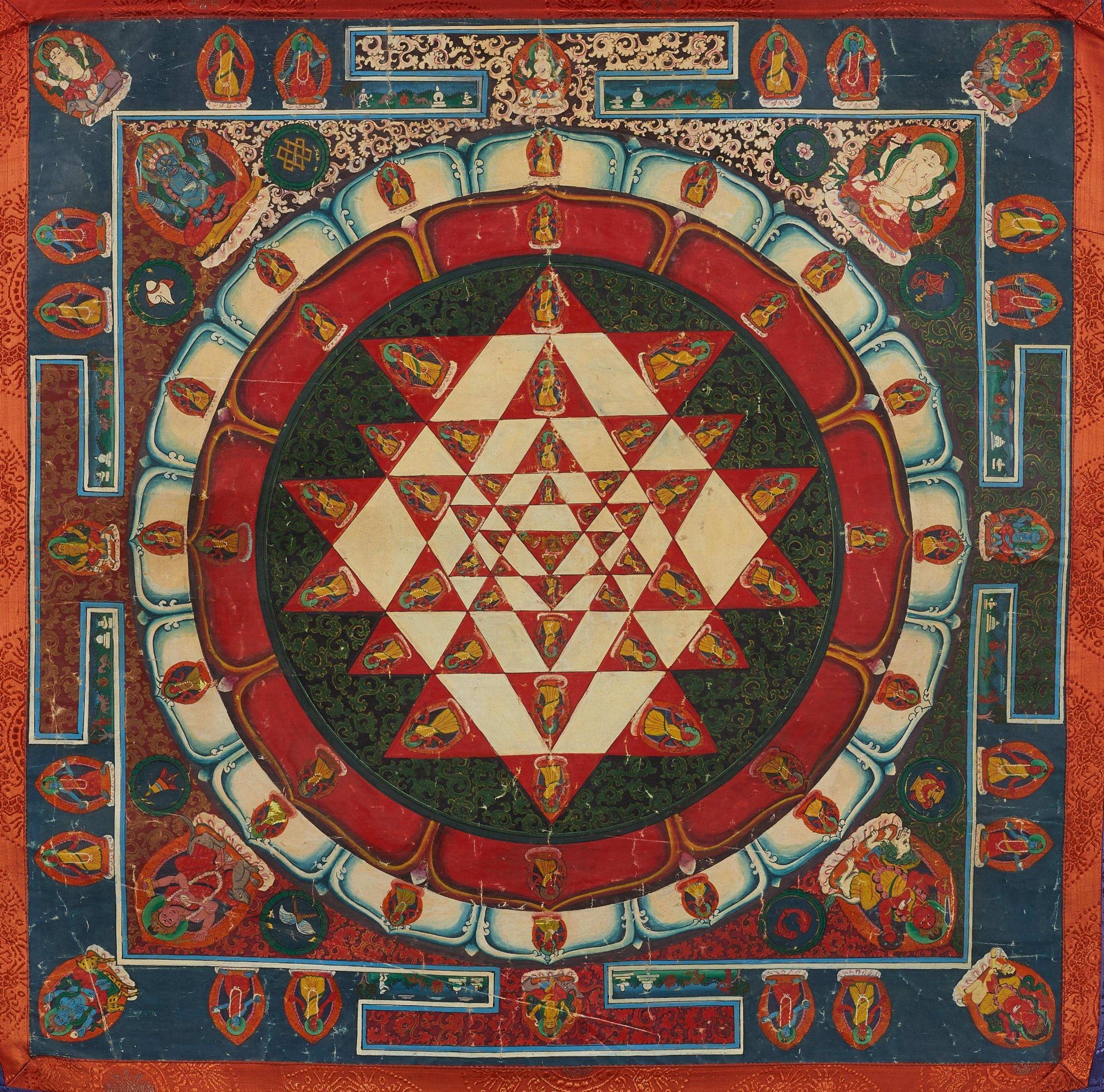 SRI YANTRA MANDALA. Nepal. Colors and gold on fabric, mounted with silk fabrics. Several figures are