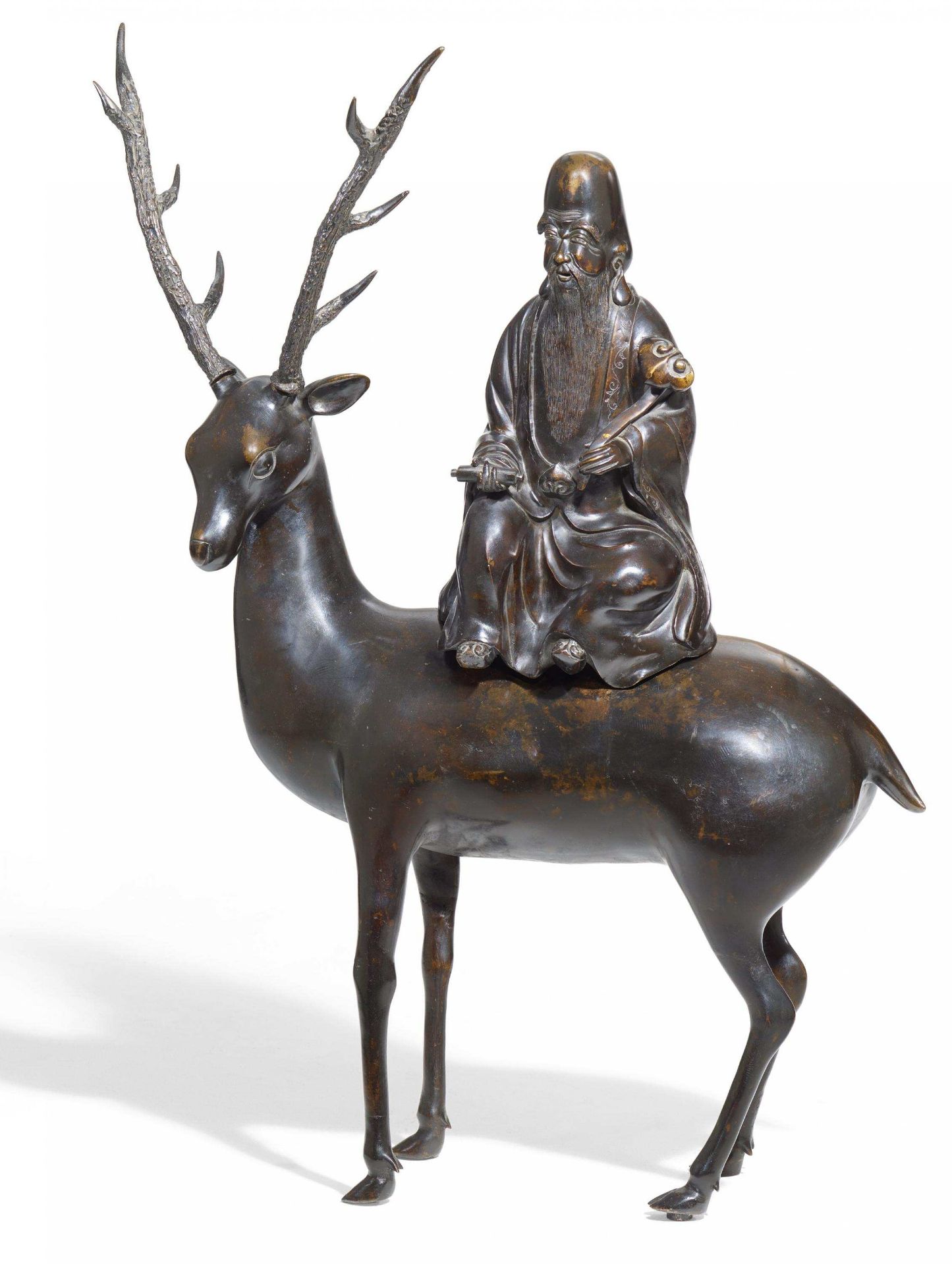 SHOULAO SITTING ON A DEER. China. 17th/18th c. Copper bronze with dark, shiny patina and residue