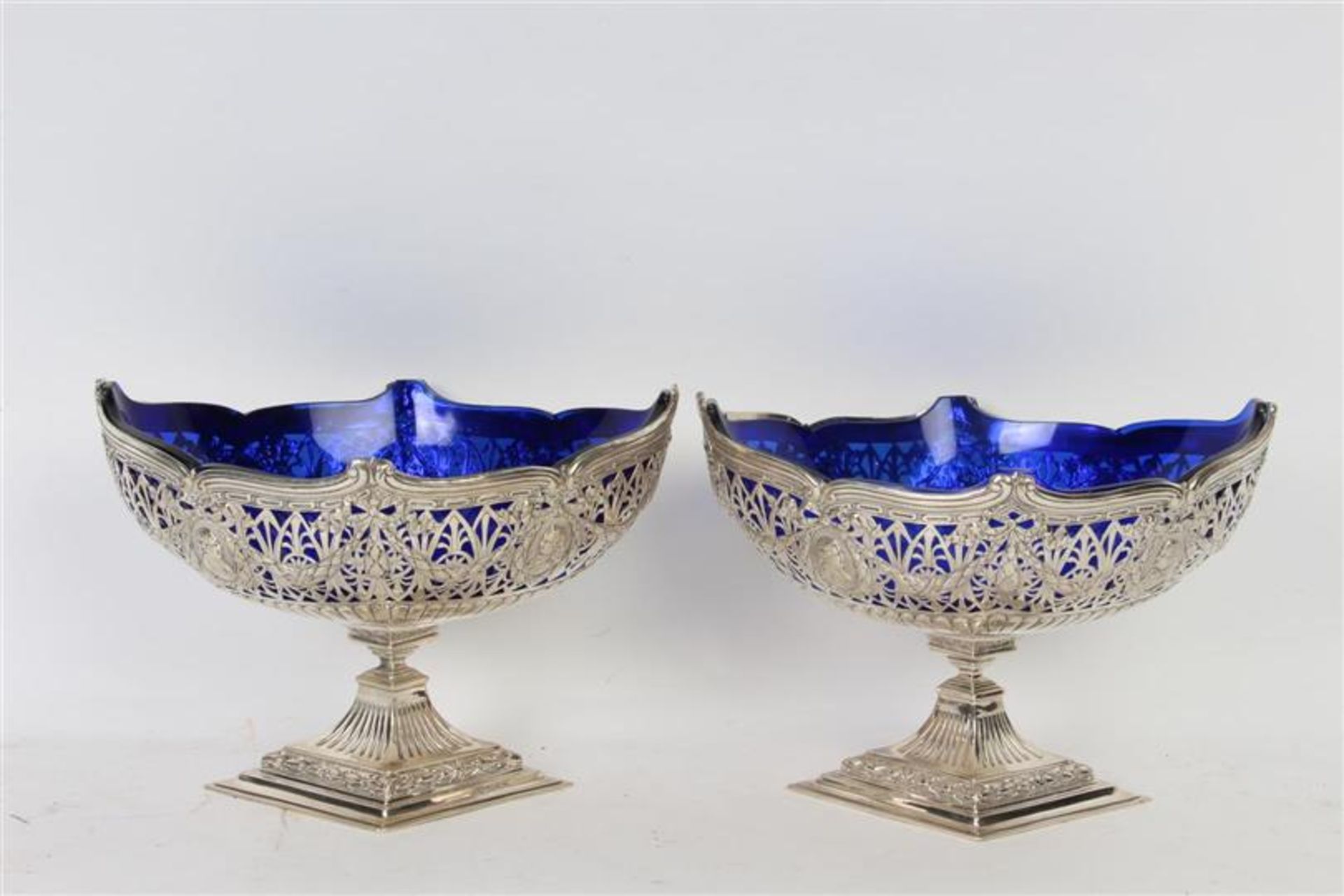 Twee coupes op voet met blauw glazen binnenbak en decor van palmetten, guirlandes en strikken, 800