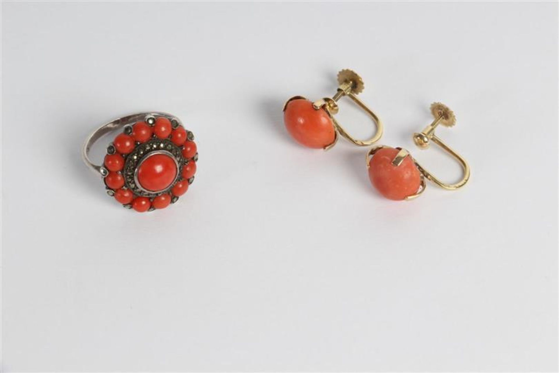 Twee gouden oorclips en zilveren ring, alle met bloedkoraal. Ringmaat: 16, Gewicht: 7.3 g.