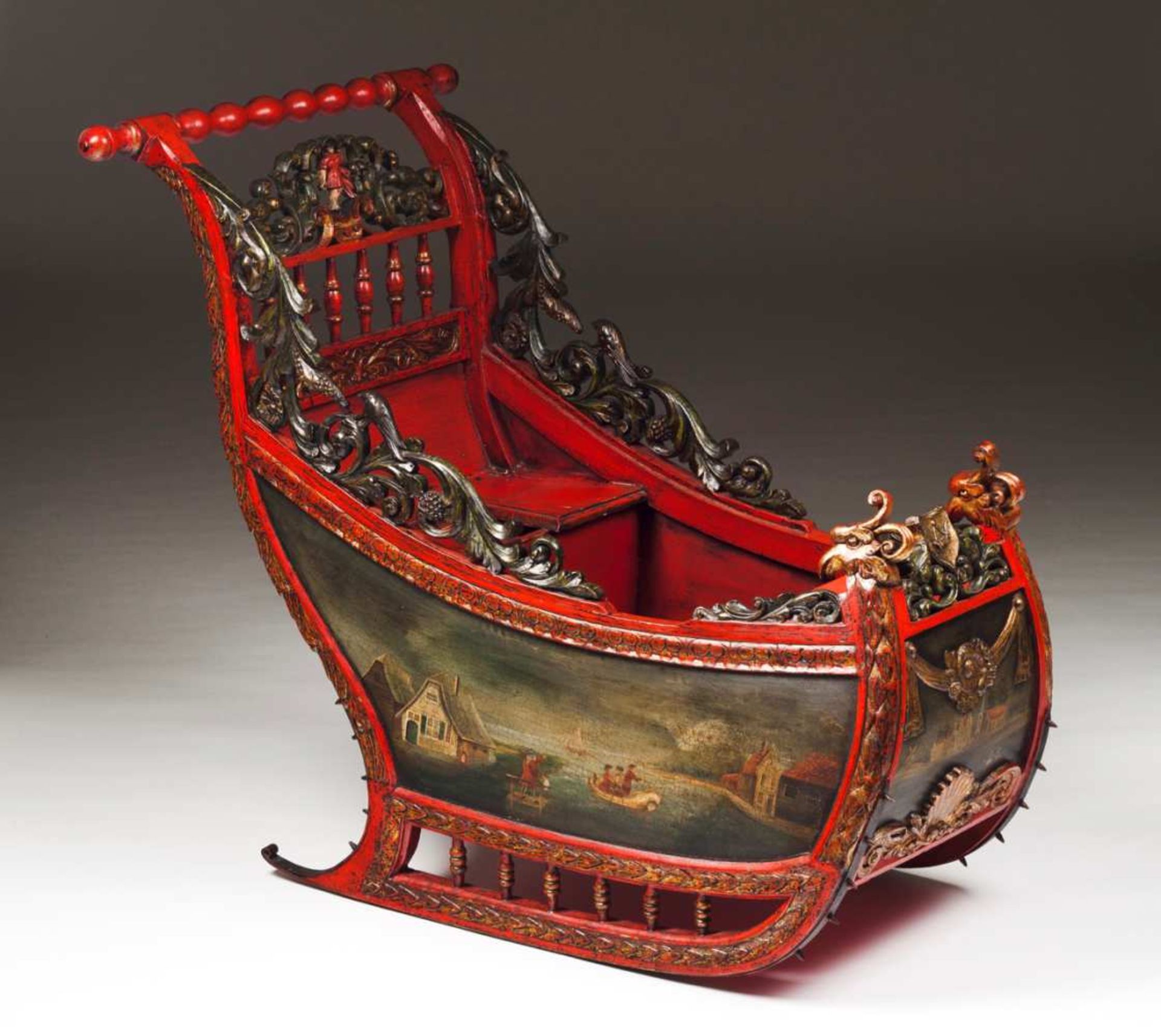 A children sled Painted and gilt wood Turned handle, carved back with figure at the centre and