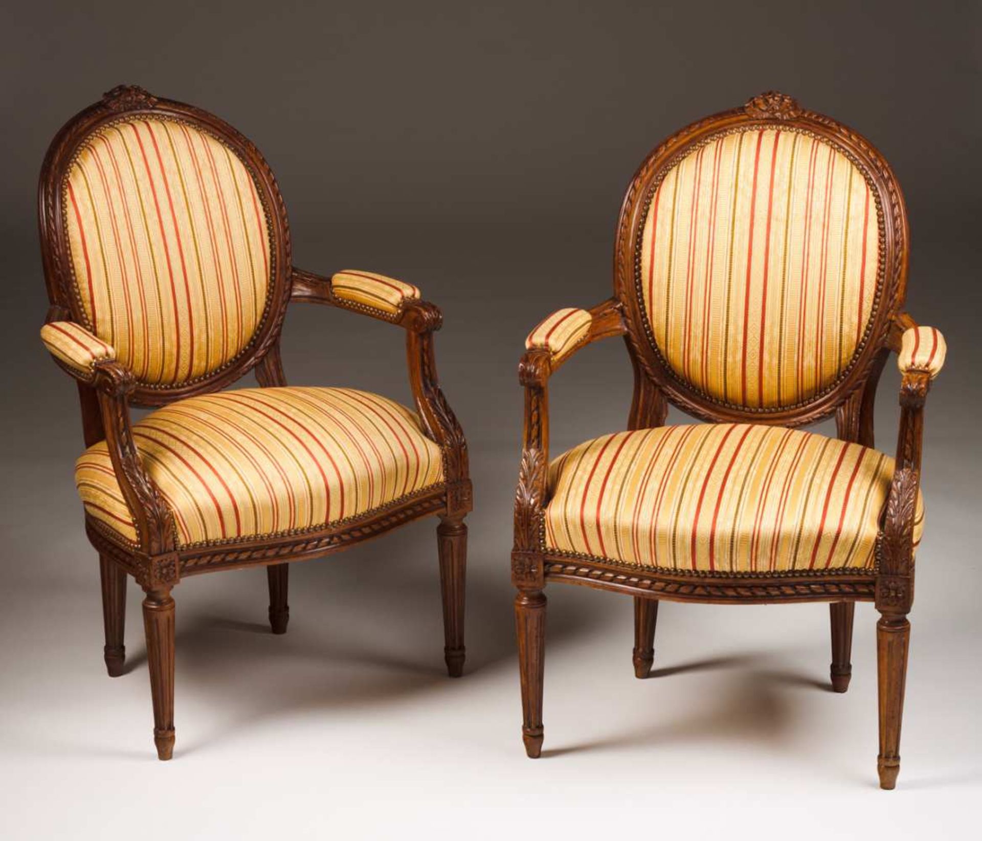 A pair of Louis XVI style fauteuils Walnut Carved decoration with floral motifs and ribbons