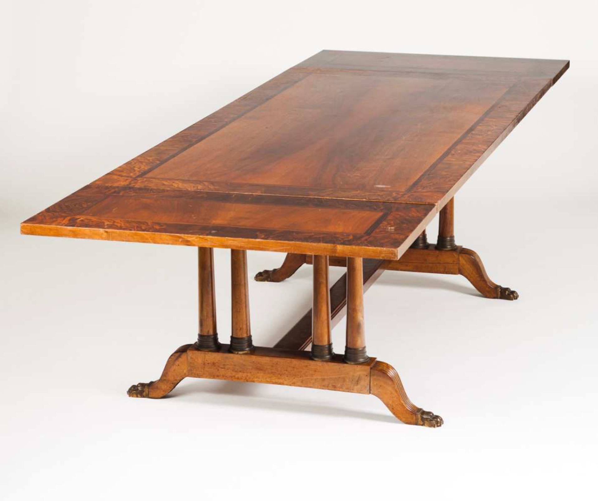 A dining table Mahogany and burr-elm On doric columns with brass claw feet With two extension boards