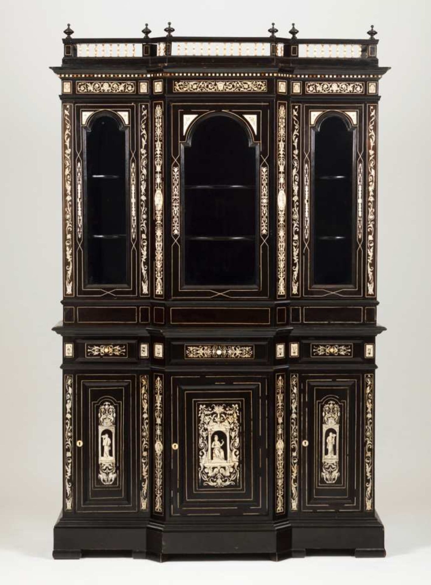 A showcase Ebony veneered with ivory inlaid decoration depicting floral scrolls, masks and