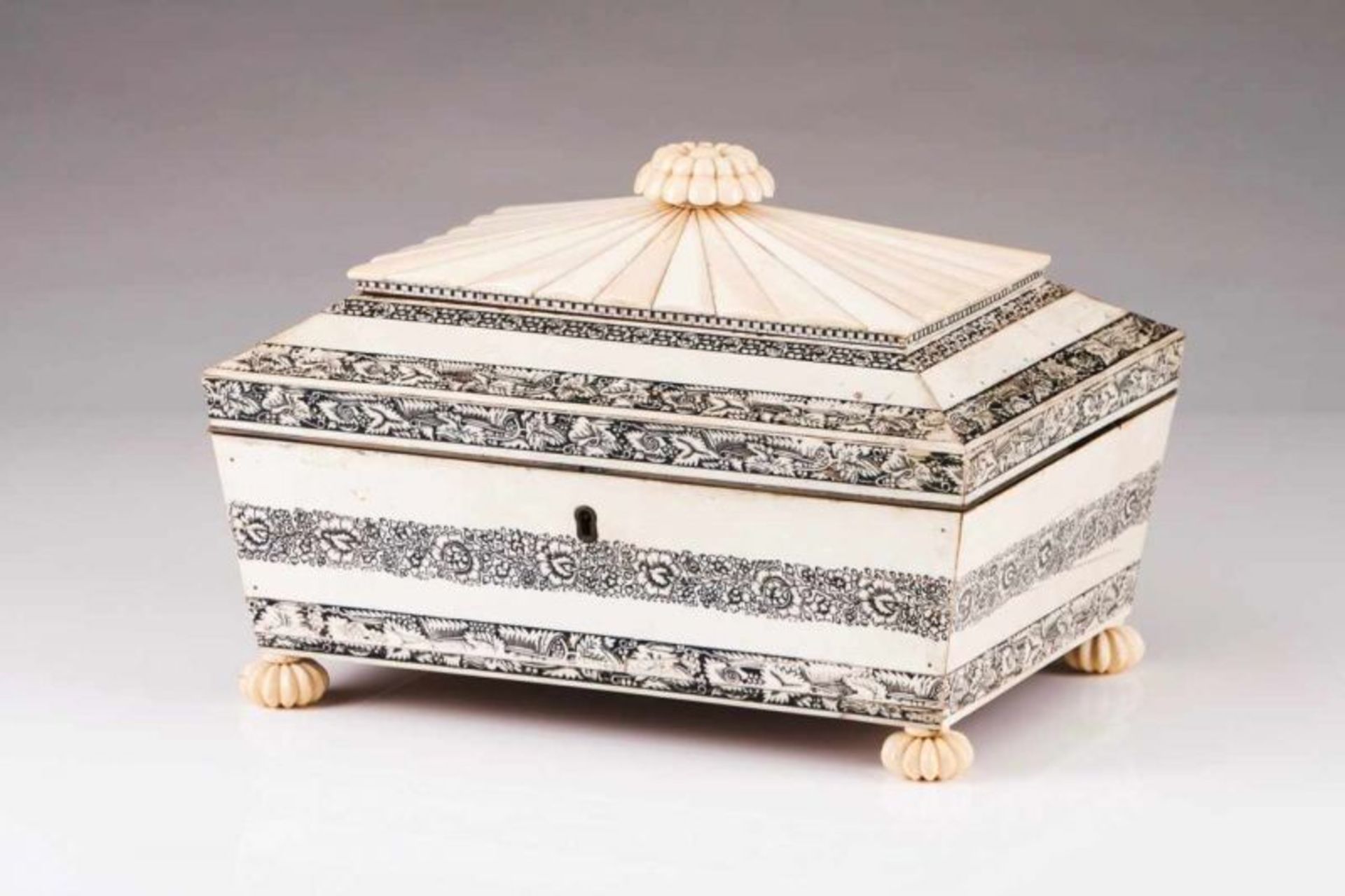 An Anglo-Indian sewing box Ivory veneered wood Sarcophagus shaped body decorated with black floral