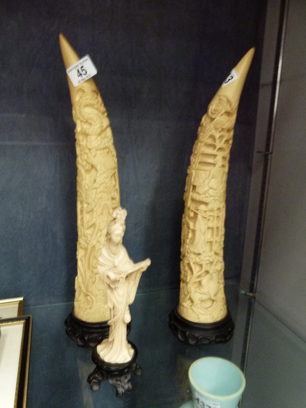 Pair of resin tusks and an Oriental figurine bearing registration mark