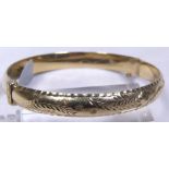 HINGED BANGLE. 9 ct gold engraved hinged