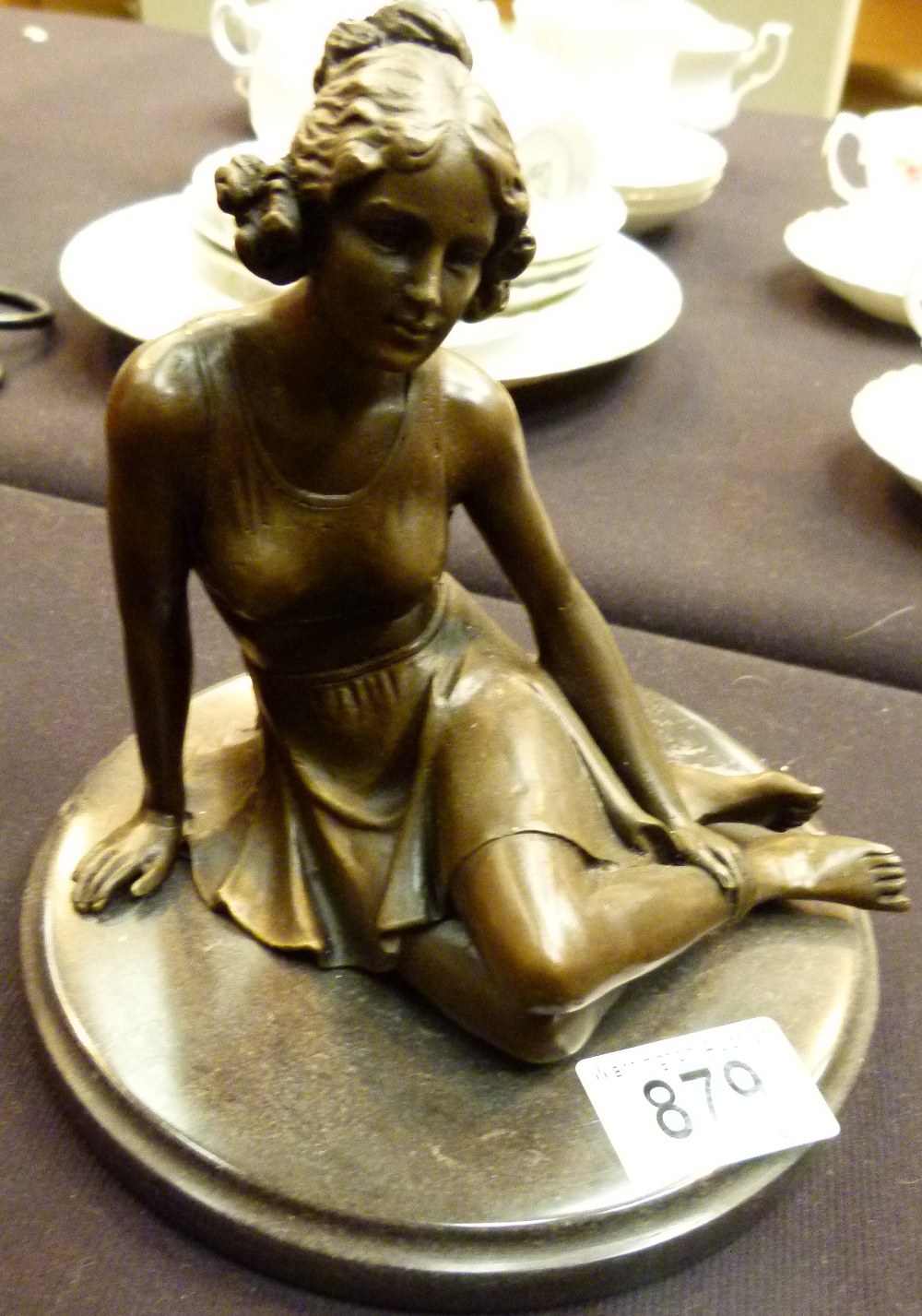 BRONZE SITTING GIRL. Bronze of a girl si