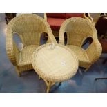 Two cane conservatory arm chairs and matching table