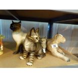 Four ceramic cats and a lioness figure