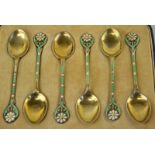 A set of six silver and enamel coffee spoons, the terminals moulded as flowers and leaves,