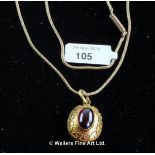 Garnet set locket pendant, central oval cabochon cut garnet mounted in an oval yellow metal
