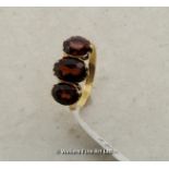 Three stone garnet dress ring, oval cut garnets mounted in yellow metal tested as 9ct, ring size O