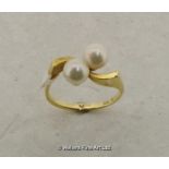 Mikimoto ring set with two cultured pearls, mounted in a yellow metal twist design, stamped and