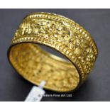 Openwork floral bangle in yellow metal tested as 18ct, weight 32.2 grams