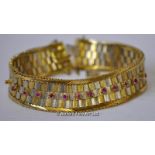 Bicolour fancy link bracelet stamped and tested as 18ct, set with thirteen rubies, safety chain