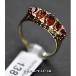 *Five stone garnet ring, graduating oval cut garnets each set with two small diamonds in between, in