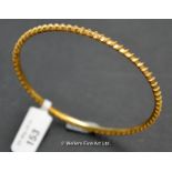 Fixed bangle with twisted wire diagonal decoration, in yellow metal tested as 18ct, weight 13.1