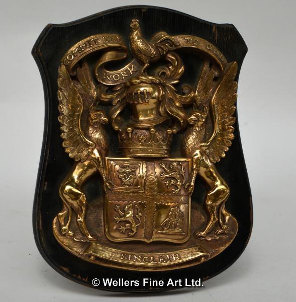 A bronze coat-of-arms for the Sinclair family, mounted on an ebonised oak shield, the shield stamped