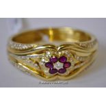 Ruby and diamond bangle, central floral design set with an oval cut diamond, surrounded by six