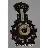 *A late 19th Century German Black Forest aneroid barometer in carved frame. (Lot subject to VAT)