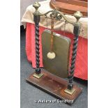 A Victorian brass and oak gong, the stand with barleytwist supports, with beater, 86cm high,