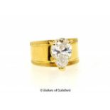 White zircon ring, white pear shaped zircon mounted on a wide yellow metal band stamped 18ct, ring