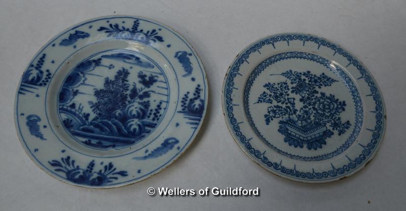 Two delftware plates, one decorated with flowers in a pot, 20cm diameter; the other with a landscape