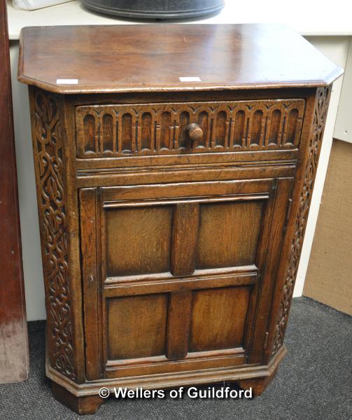 An oak side cupboard with canted front corners, single drawer to the top over a cupboard door, 91