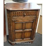 An oak side cupboard with canted front corners, single drawer to the top over a cupboard door, 91