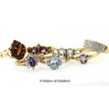 Seven 9ct gold gem set rings, including a garnet cluster ring, amethyst and diamond ring and a