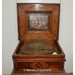 An oak cased polyphon retailed by P v Leeuwen & Zn, the case with classical print set inside lid,