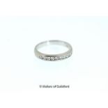 Diamond half eternity ring, nine round brilliant cut diamonds channel set in white metal stamped