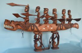 A large African tribal boat and figures on stand.