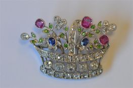 An attractive platinum brooch in the form of a basket of flowers inset with rubies, sapphires and