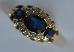 An 18 carat sapphire and diamond oval cluster ring