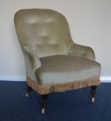 A small button back nursing chair with brass casto