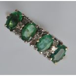 An 18 carat thirteen stone emerald and diamond clu