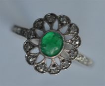 An attractive Edwardian emerald and diamond cluste