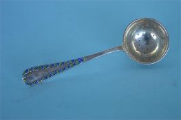 LIBERTY & Co. An unusual enamelled tea strainer wi